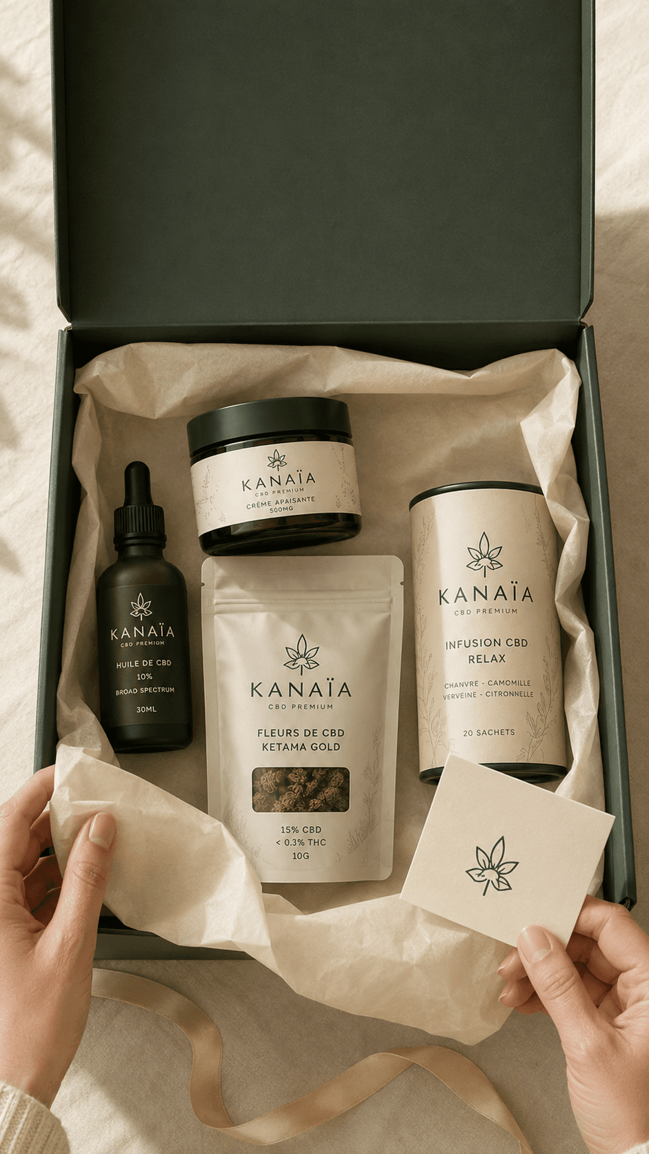 Le coffret cadeau KANAÏA ouvert : huile, crème, fleurs et infusion dans leur papier de soie